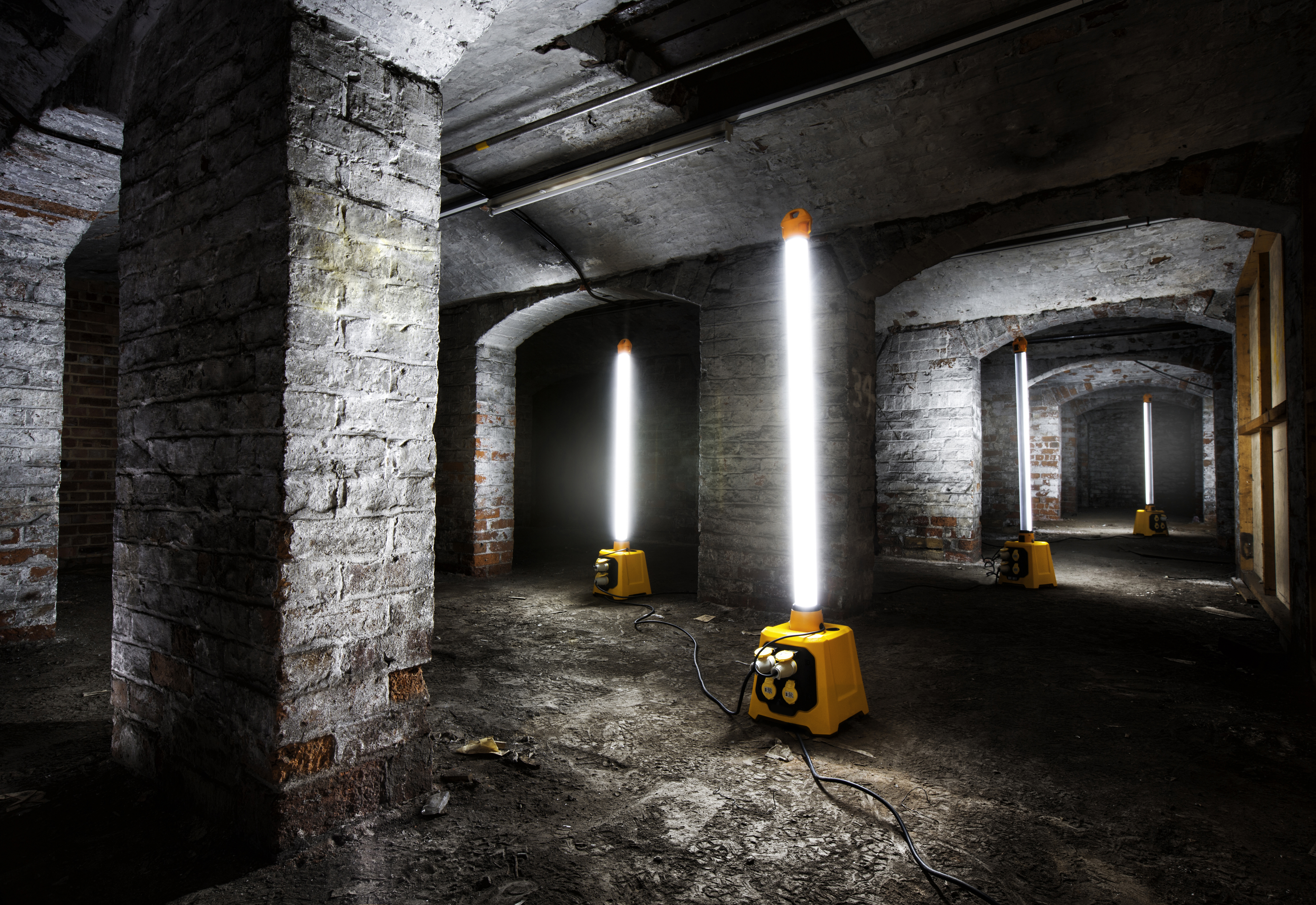 Portable plasterer's lights shown illuminating tunnel area.