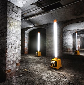 Portable plasterer's lights shown illuminating tunnel area.