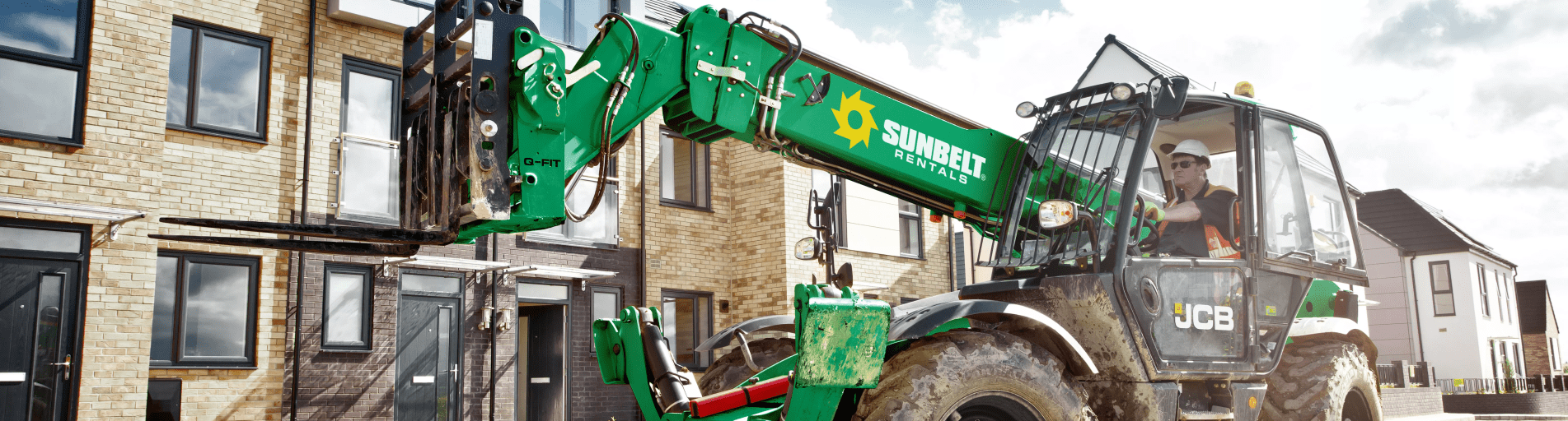 Worker in Sunbelt Rentals plant machinery performing construction tasks